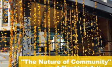 picture of yellow flowers hanging from pavilion at Broadway Square, white text that says The Nature of Community a floral installation