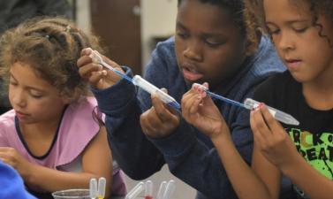 Photo of three children doing a science experiment