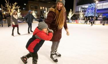 Woman and child skating in outdoor rink