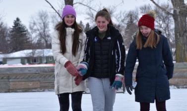 three girls skating on outdoor skating rink