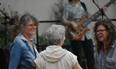 Photo of three women dancing to live band at broadway square