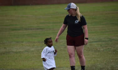 Photo of fargo parks employee teaching fitness to child.