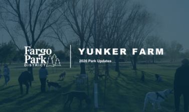 Fargo Park District graphic titled “Yunker Farm: 2026 Park Updates,” featuring a blue-tinted photo of visitors and dogs gathered in an open park beneath leafless trees.