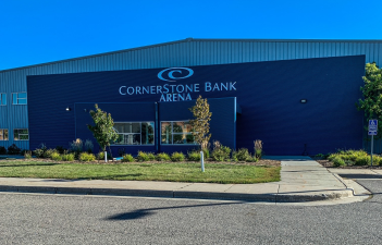 This photo shows the front of Cornerstone Bank Arena - a blue building with the Cornerstone Bank Logo