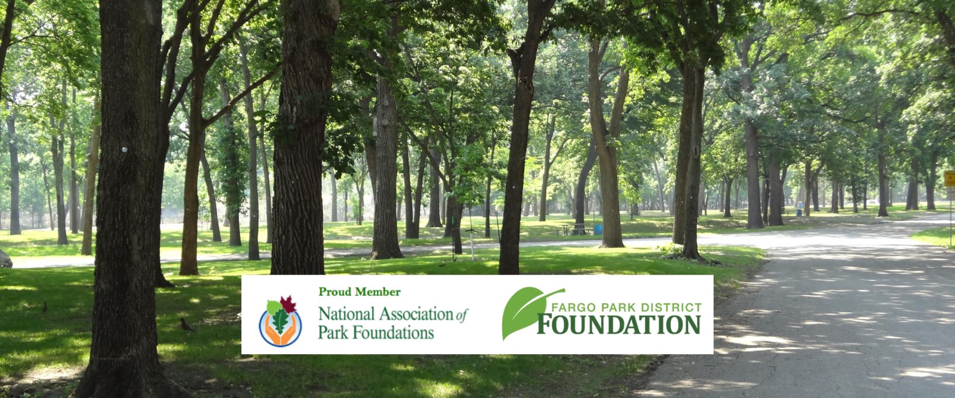This photo shows a park with trees with the Fargo Park District Foundation logo and the National Parks Foundation Logo