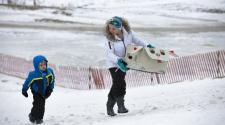 This image shows two kids walking up the hill at the 2017 Cardboard Sled Race