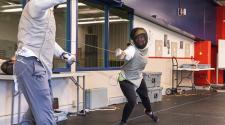 This image shows two people practicing during the adult fencing program.