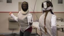 This image shows two girls in a fencing duel at the youth fencing program.