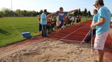 This image shows a boy doing the long jump during the track and field program.