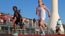This image shows two girls racing during a track and field program.