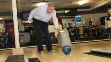 This image shows a male bowling with the adaptive bowling program.
