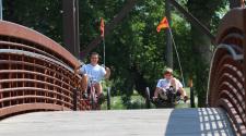 This image shows two kids riding bikes across the bridge at Lindenwood Park