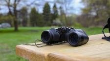 This image shows a pair of binoculars on a table for the birding program.