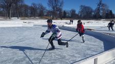 This image shows two players skating at the Fargo Pond Hockey Classic.
