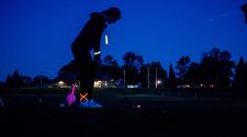 This image shows a female about to hit her ball at Glow Golf.