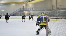 This image shows the goalie getting ready to make a save at adult hockey.
