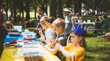This image shows some kids making crafts at a table during Midwest Kids Fest.
