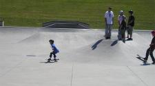 This image shows a young boy skateboarding at the skate park.