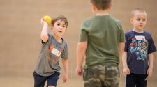 This image shows two boys playing catch at sports sampler.