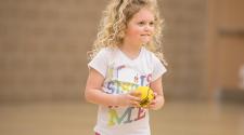 This image shows a girl holding the ball at sports sampler.