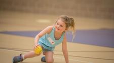 This image shows a young girl with a ball at Youth Open Gym.