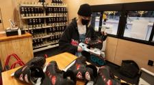 This image shows the Skate Shack worker cleaning rental skates and putting them back on the rack.