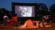 This image shows a couple watching a movie in the park at our Gathering on Tuesdays event.