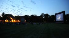 This image shows a group of people watching a movie in the park at our Gathering on Tuesdays event.