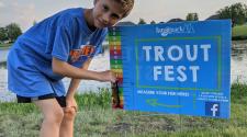 This image shows a child measuring a fish at our Trout Fest event.