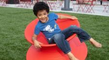This image shows a young boy on the spin chairs at Broadway Square.