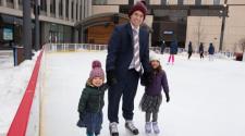 This image shows a dad and two daughters skating on SCHEELS Skating Rink at Broadway Square.