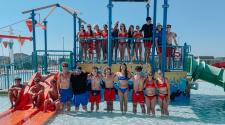 Lifeguards at the Davies Outdoor Pool standing on the aquatic playground lined up for a picture.