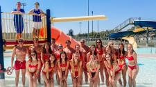 Lifeguards at the Roger E. Gress Northside Outdoor Pool standing on the aquatic playground lined up for a picture.