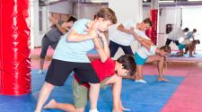 Youth work in pairs to practice self-defense holds and techniques during class.